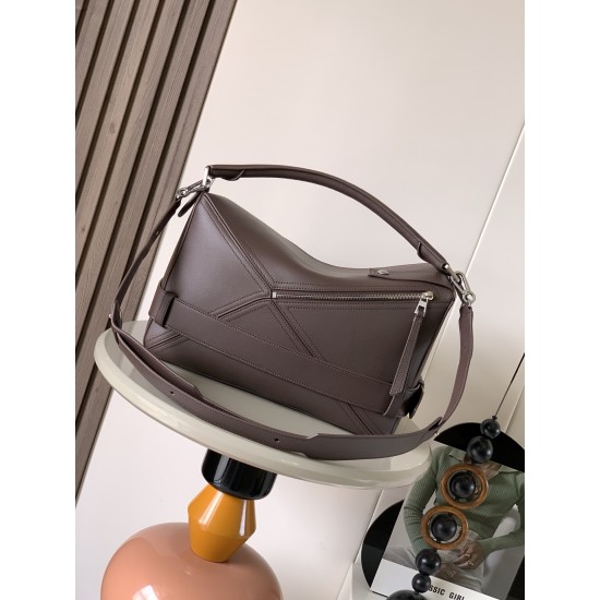 1180 Large Glossy Cowhide Puzzle Biker HandbagPuzzle with distinctive geometric lines that define the rectangular shapeThis large version is made of glossy cowhide leather with biker-inspired detailingCan be worn over the shoulderCrossbody or handheldDeta